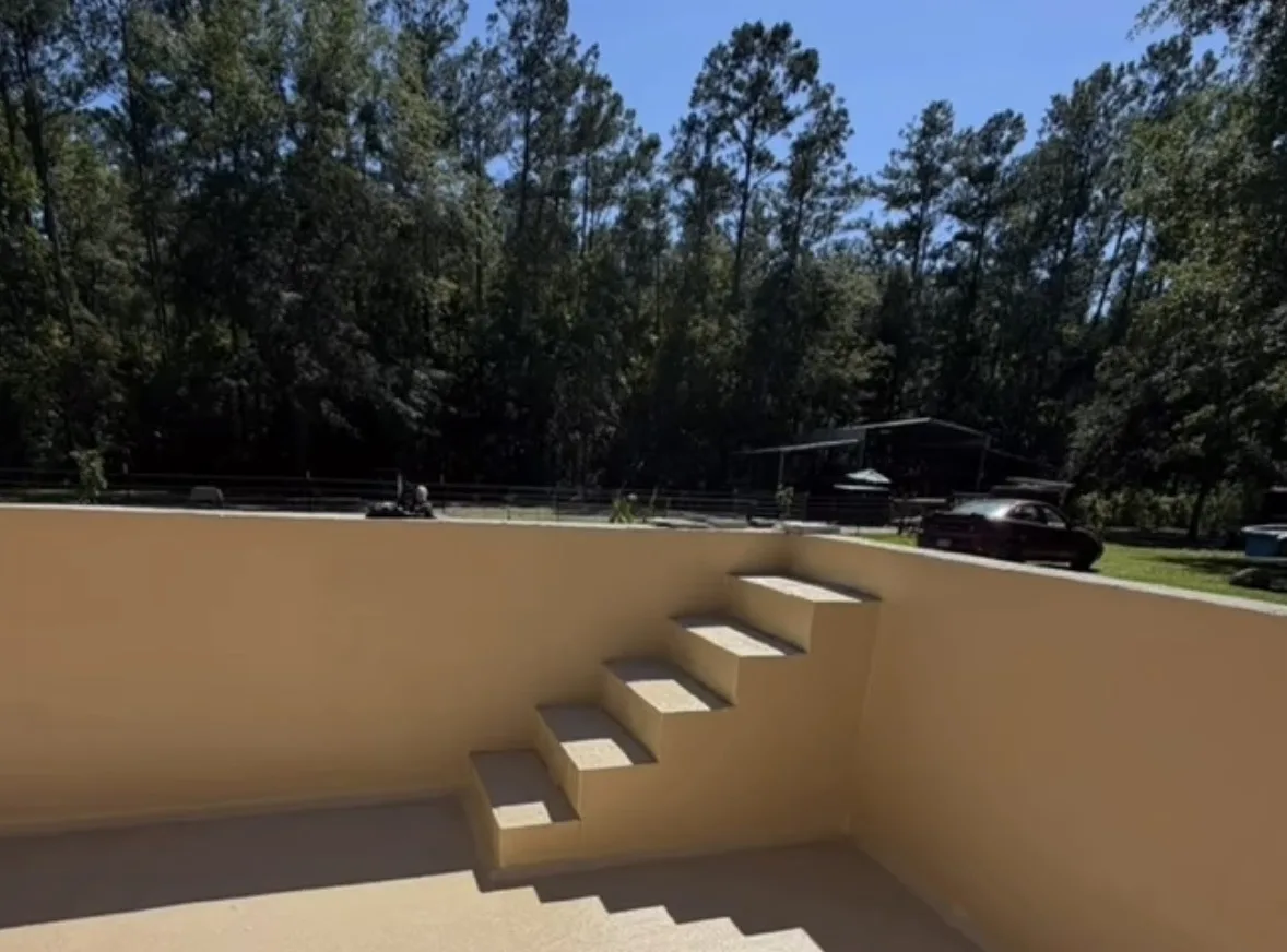 Finished pool shell with stucco walls and step-out