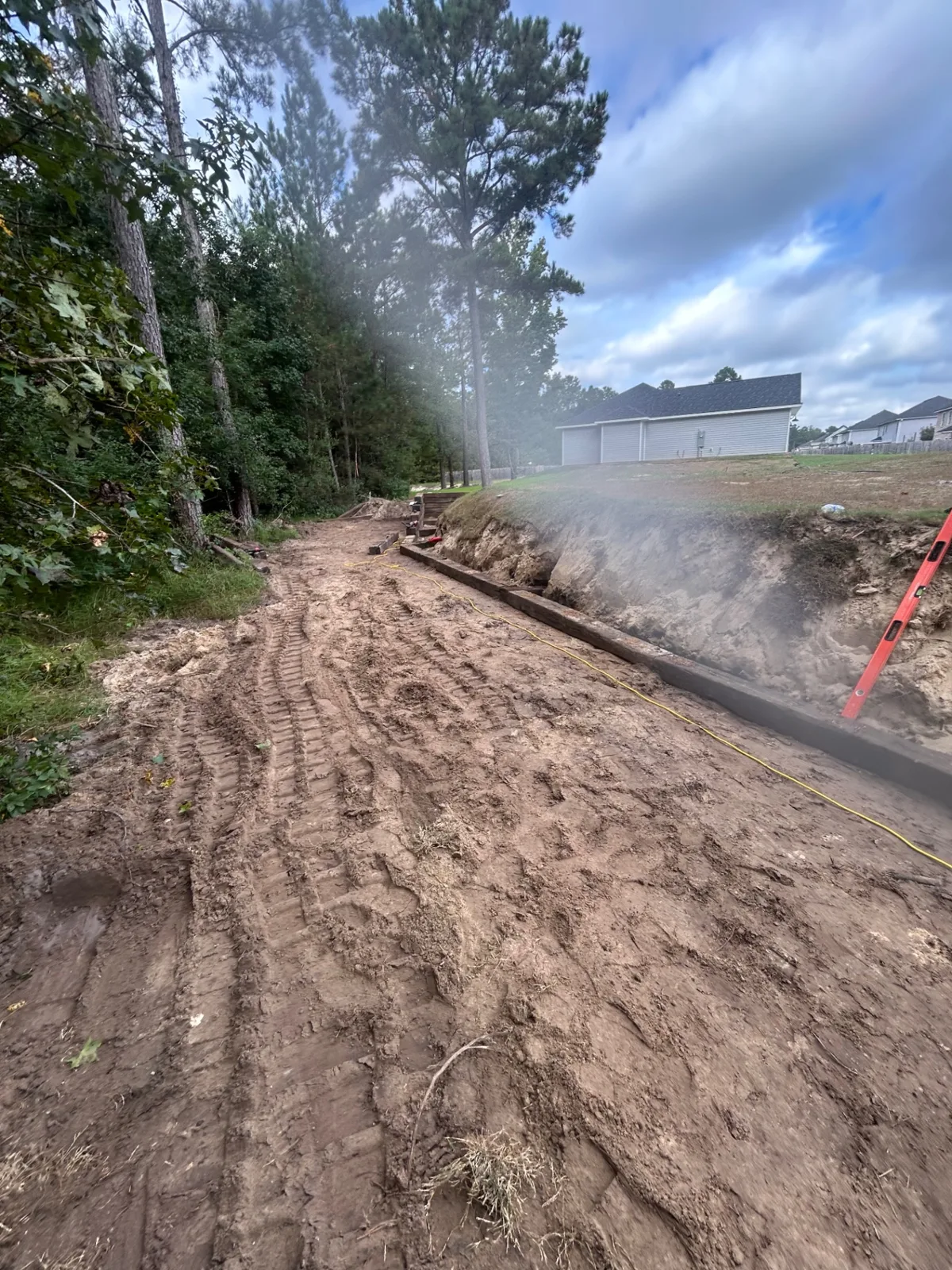 Cut-in hillside prepped for a new retaining wall run