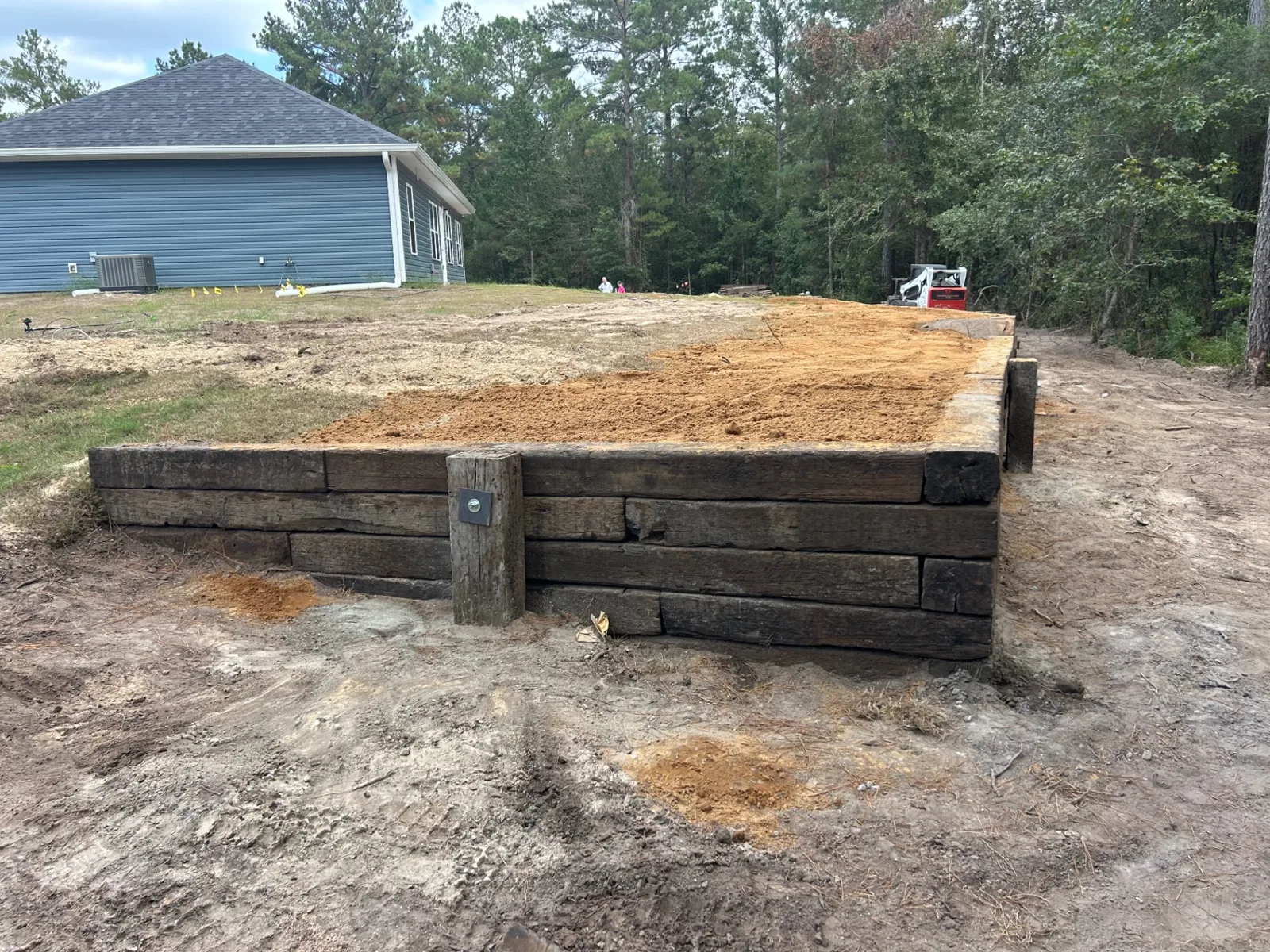 Timber retaining wall backfilled and ready for finish grade