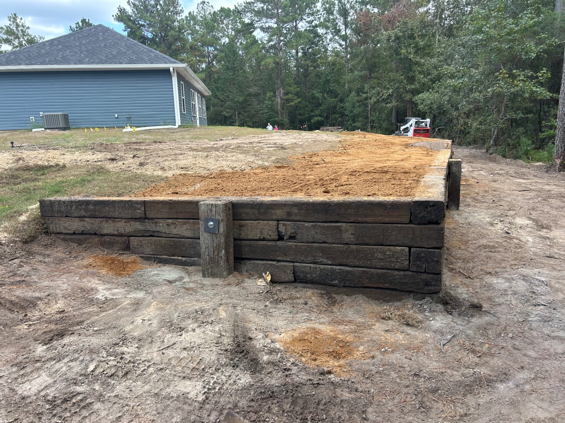 Timber retaining wall backfilled and ready for finish grade