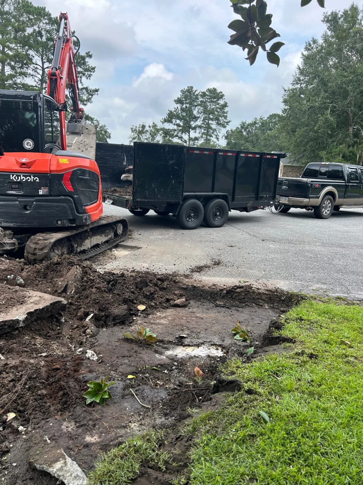 Kubota excavator + dump trailer on a demo job