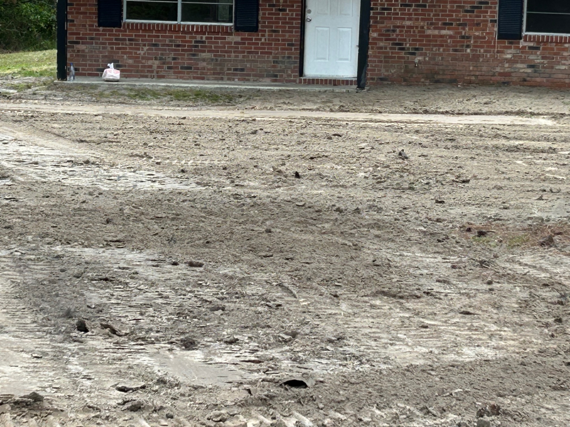 Before — muddy, rutted lot in need of grading